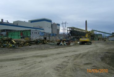Demolition work taking place over a large industrial complex