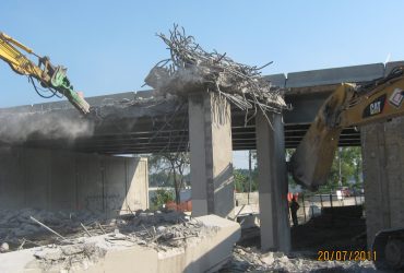 Deux excavatrices Démex démolissant la structure du pont.