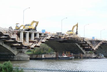 Vue latérale du pont avec trois excavatrices Démex au travail.