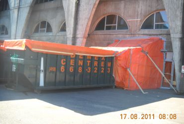 An asbestos container with the access door adequately sealed to prevent dispersion of asbestos particles