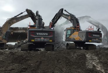 Four Démex excavators demolishing elements of the concrete bridge structure