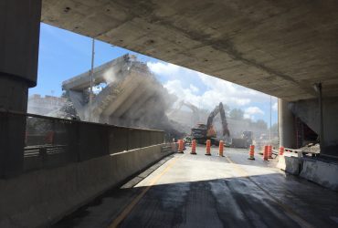 Two Démex excavators busy demolishing a massive concrete section of the bridge