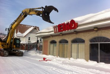 A Démex excavator about to tear down the front wall of a Metro store.