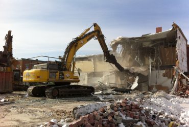 View of a Démex excavator demolishing a two storey house