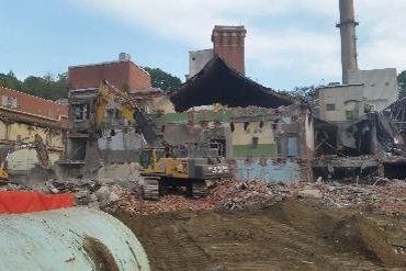 Ground level view of an excavator in a cleared out area.