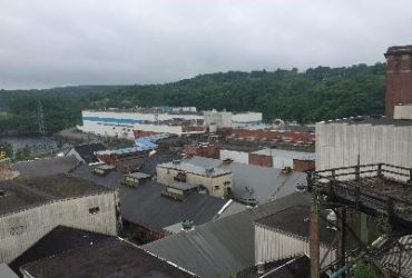 Vue éloignée de l'usine et de la rivière à proximité, avant que la démolition ne commence.