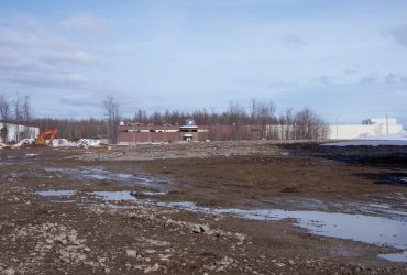 Vue du terrain de l'usine après la démolition, le sol libre et à niveau.