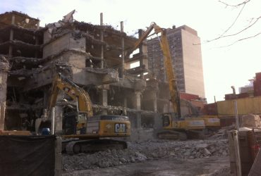 Three excavators demolishing the top floors