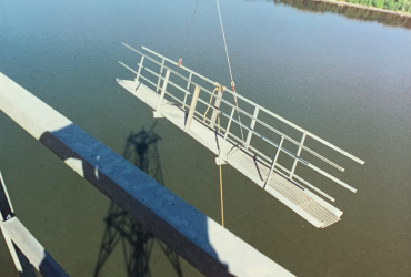 Metal structure taken down onto a barge on the river