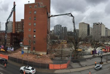 Panoramic view of the demolitiono of the Children Hospital in Montréal, showing two excavators equiped with a high reach boom.