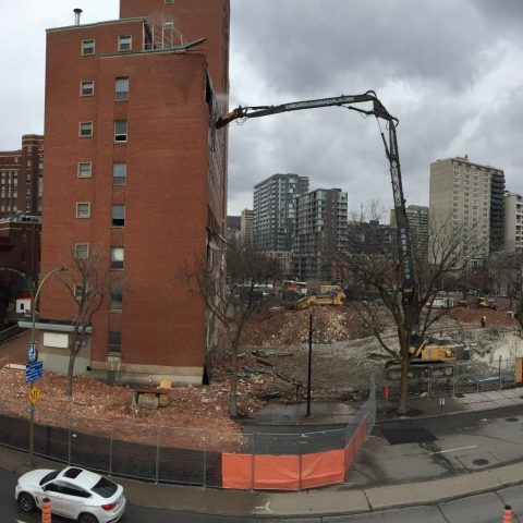Panoramic view of the demolitiono of the Children Hospital in Montréal, showing two excavators equiped with a high reach boom.