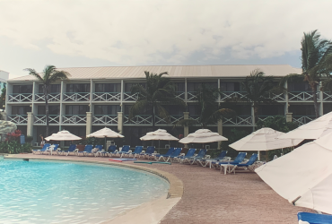 Vue d'une des ailes de chambres avec piscines, parasols et chaises longues, avant la démolition.