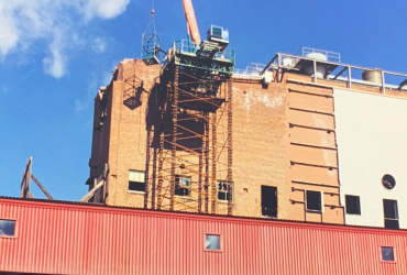 Grue à l'oeuvre sur le toit d'un bâtiment élevé