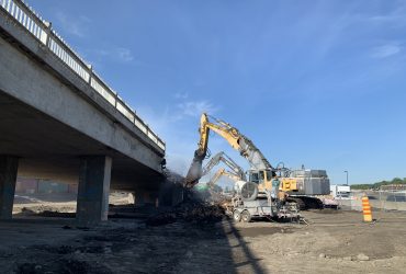 Vue de plusieurs excavatrices broyant le béton d'une rampe d'accès au niveau Angrignon..