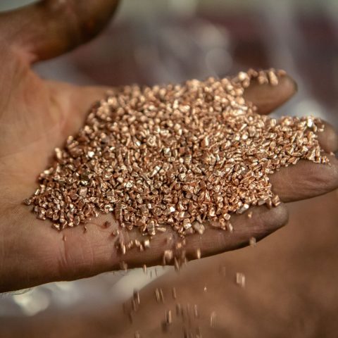 Vue d'une main emplie de granules de cuivre produites dans le centre de recyclage Centrem à Alma.