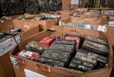 Vue de plusieurs caisses de carton remplies de batteries usagées pour revente, à l'intérieur du centre de recyclage.