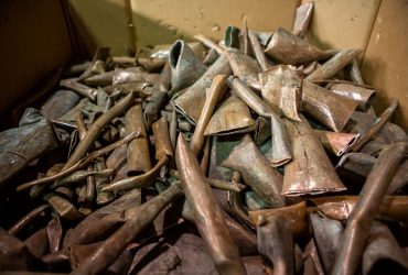 Vue de morceaux de vieux tuyaux de cuivre pour recyclage dans un boîte de carton.