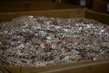 Vue d'une caisse en carton remplie d'anneaux d'ouverture de canette pour fin de recyclage., à l'intérieur du centre de recyclage