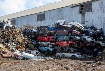 Car carcassess piles outside at Centrem recycling center in Alma