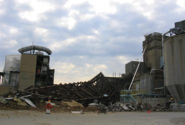 Photographie d'un autre angle d'une partie de l'usine Tembec à Kapuskasing en Ontario, avec vue de ce qu'il reste de la structure métallique de l'atelier de production d'acide au sol.
