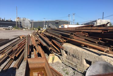 Vue d'une pile de voies ferrées destinées au recyclage par temps ensoleillé.