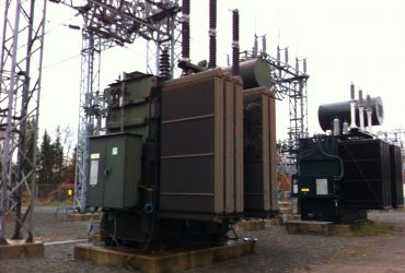 Vue de deux transformateurs encore dans la sous-station électrique, par temps gris.