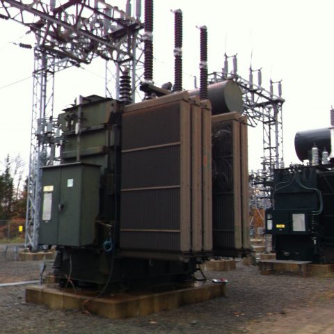 Vue de deux transformateurs encore dans la sous-station électrique, par temps gris.