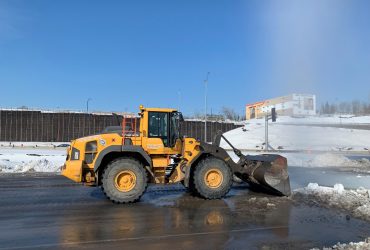 Vue d'un chargeur sur roues en train de retirer la neige sur le pavé du centre de recyclage Centrem à Alma par beau temps.