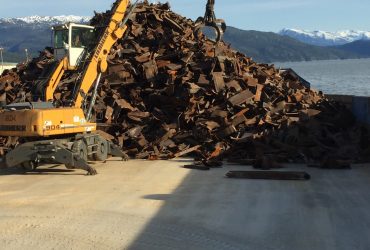 Vue d'une excavatrice de manutention Centrem munie d'un grappin pour empiler les métaux ferreux.