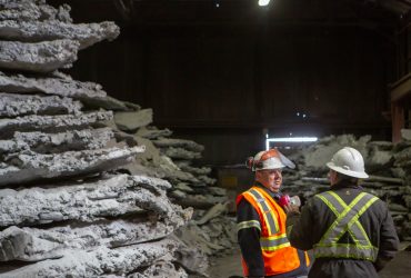 Vue de deux employés Centrem en discussion à côté d'une pile de sous-produits de fabrication d'aluminium au centre de recyclage Centrem à Alma.