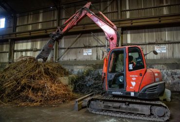 Vue d'un Kubota muni d'une cisaille, à l'oeuvre dans le centre de recyclage Centrem à Alma.