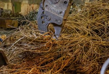 Shear on a Kubota excavator handling scrap wire at Centrem recycling center in Alma